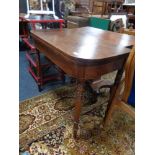 A George III mahogany turnover top table on turned legs