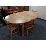 An Ercol elm extending kitchen table and set of four rail backed chairs