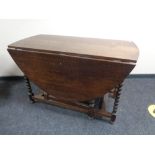 A Victorian oak drop leaf table on barley twist legs