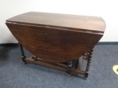 A Victorian oak drop leaf table on barley twist legs