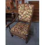 A carved oak scroll arm armchair in tapestry fabric