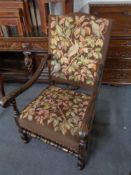 A carved oak scroll arm armchair in tapestry fabric