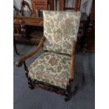 A carved oak scroll arm armchair in tapestry fabric