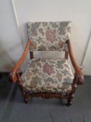 A 20th century carved oak scroll arm armchair