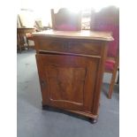 An antique mahogany single door cabinet on bun feet