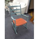 A mid century ladder backed rocking chair