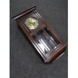 An early 20th century oak cased wall clock with brass and silvered dial,