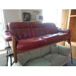 A late 20th century wooden framed three seater settee in red button leather