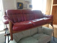 A late 20th century wooden framed three seater settee in red button leather