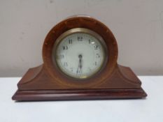 An antique French inlaid mahogany mantel clock on raised brass feet, with key.