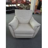 A cream leather swivel reclining armchair