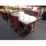 An early 20th century oak refectory table and four chairs in maroon fabric