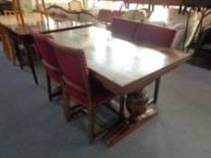 An early 20th century oak refectory table and four chairs in maroon fabric