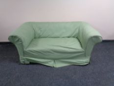 An Edwardian settee upholstered in a gold dralon fabric with loose cover