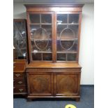 A Regency mahogany double door bookcase fitted with cupboards beneath