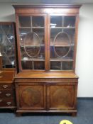 A Regency mahogany double door bookcase fitted with cupboards beneath