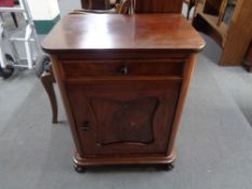 An antique mahogany and pine single door cupboard