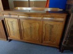 An early 20th century mahogany triple door sideboard on paw feet