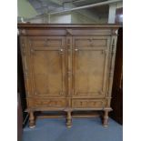 A 20th century oak double door cabinet on raised legs