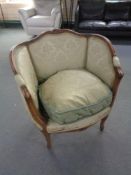 A 20th century beech framed armchair in green brocade