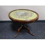 An antique mahogany pedestal wine table with tapestry panel top