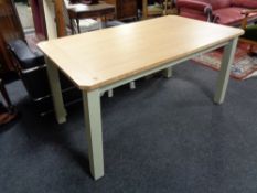 A contemporary oak topped pull out table on painted legs