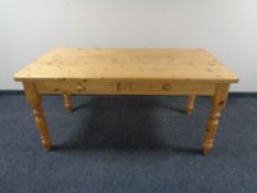 A pine farmhouse kitchen table together with a set of six rush seated ladder backed chairs