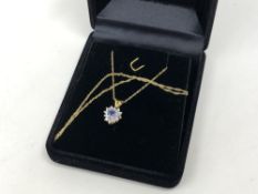 A tanzanite and diamond pendant on 10ct gold chain