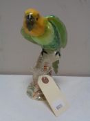 A Beswick figure of a parrot on branch.