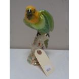 A Beswick figure of a parrot on branch.