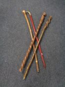 A bundle of four walking sticks including a brass cobra headed stick.