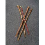 A bundle of four walking sticks including a brass cobra headed stick.