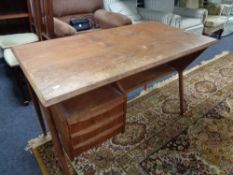 A mid century teak desk fitted with three drawers CONDITION REPORT: Cosmetically