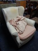 An antique horsehair wing backed chair with loose covers