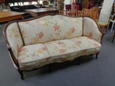 A French style wooden framed settee in cream floral fabric
