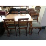 A 20th century oak dining table and six oak chairs in striped fabric