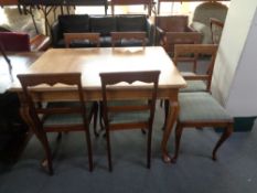 A 20th century oak dining table and six oak chairs in striped fabric