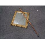 An antique gilt framed composition mirror together with a silver topped walking stick