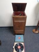 An early twentieth century oak gramophone in oak cabinet together with 78's