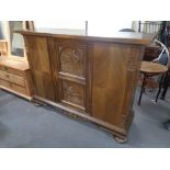 A 20th century carved oak triple door sideboard