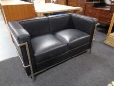 A contemporary black leather and metal two seater settee