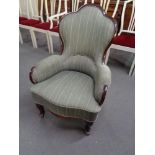 A shaped Art Deco wood framed armchair in striped fabric