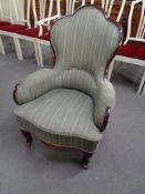 A shaped Art Deco wood framed armchair in striped fabric