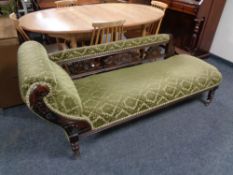 An antique chaise longue in green fabric