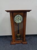An early 20th century mahogany eight day wall clock, with brass and enamelled dial,