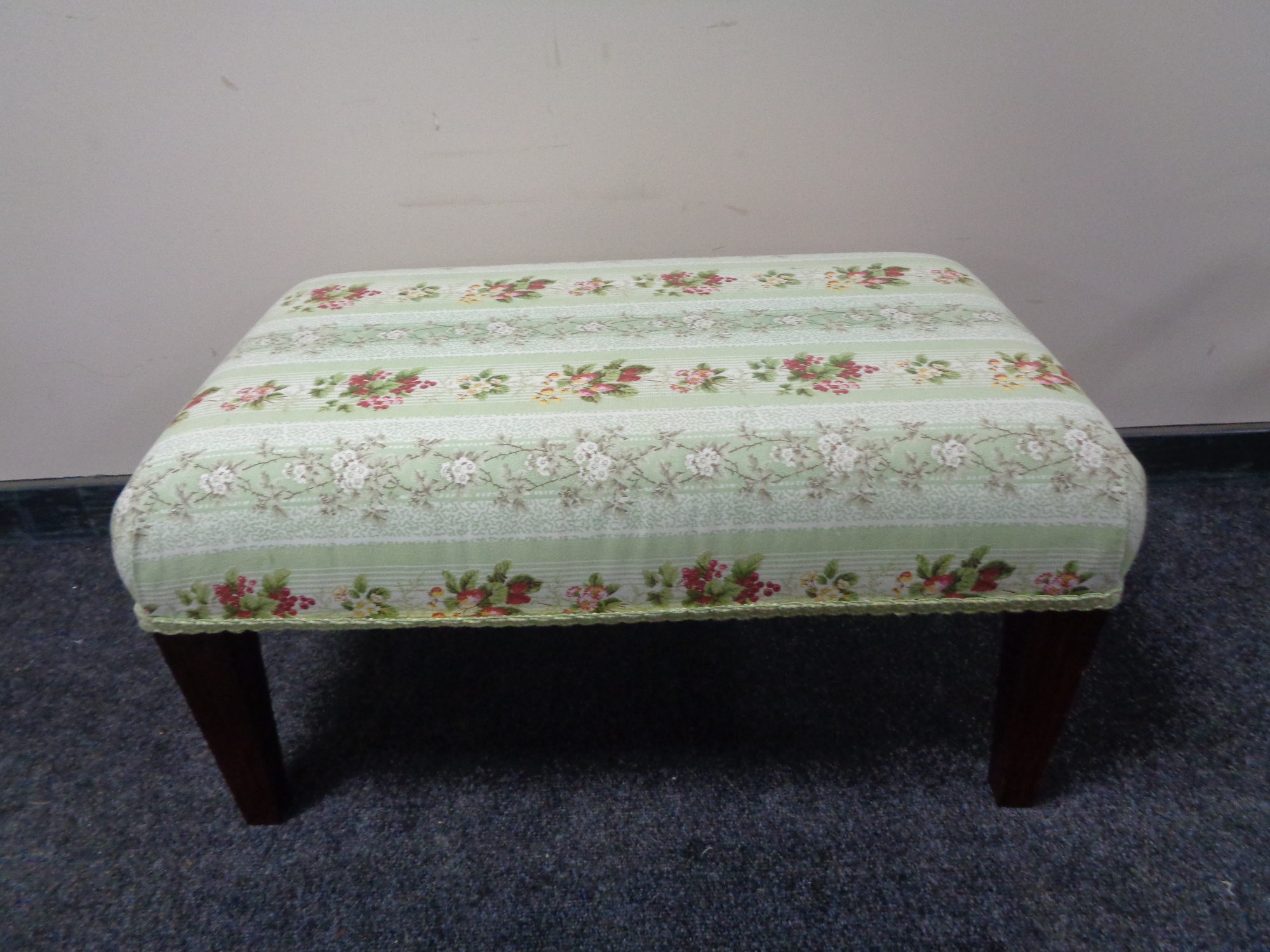 A hand made footstool upholstered in floral fabric