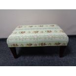 A hand made footstool upholstered in floral fabric
