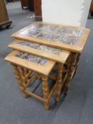 A nest of three blonde oak tiled topped tables