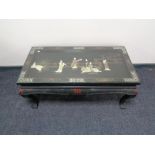 A lacquered Japanese style low coffee table with glass top