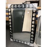 A black circular design glass mirror,